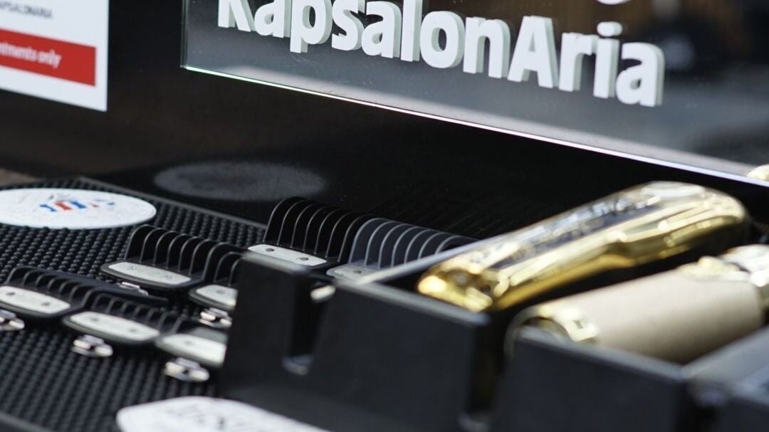 Glazen KapsalonAria bord boven het rek met opzetkammen en gouden tondeuses